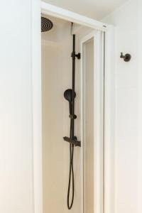 a shower in a bathroom next to a door at Trepat Harbor's Light in Villajoyosa