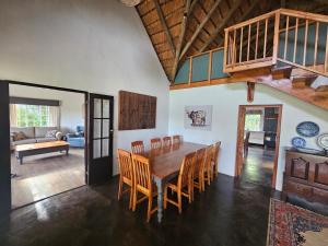 a dining room with a wooden table and chairs at Pearse Farm Stay in Howick