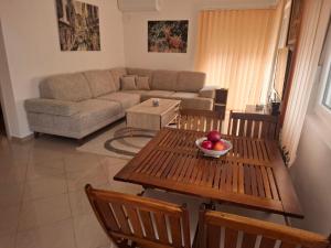 a living room with a couch and a table with a bowl of fruit at Dara Apartmani in Donji Štoj