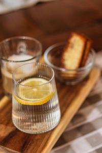 a glass with a slice of lemon and a bowl of bread at Etno Garden Exclusive in Plitvička Jezera