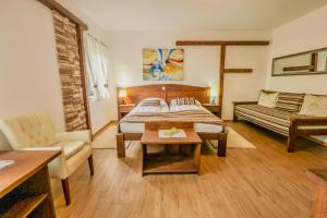 a living room with a bed and a couch at Etno Garden Exclusive in Plitvička Jezera