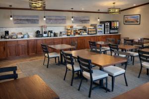 a restaurant with wooden tables and chairs and a counter at Fireside Inn and Suites in Devils Lake