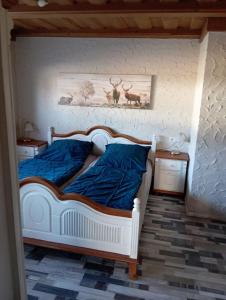 a bedroom with a bed with blue sheets and deer pictures on the wall at Ferienwohnung Lechner in Treffelstein