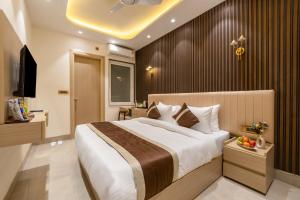 a hotel room with a large bed and a television at Hotel Silver Star in Greater Noida