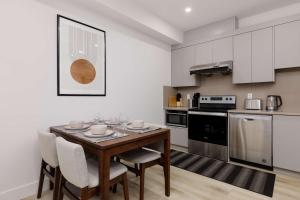 a kitchen with a wooden table and chairs in a room at Newly Built Suite-West Coquitlam in Coquitlam