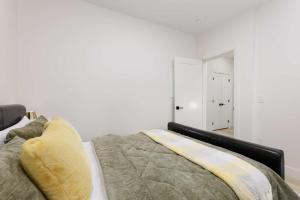 a bedroom with a bed and a white wall at Newly Built Suite-West Coquitlam in Coquitlam