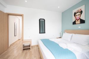 a bedroom with a bed and a painting of a woman at Topfix Luxury Home 1 in Kos