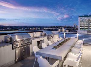 a table and chairs on a balcony with a grill at Austin Resort 2BR Apartment in Austin