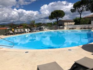 a large swimming pool with blue water at Mobilhome avec piscine in Ruoms