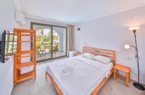 a bedroom with a large bed and a balcony at BURÇ HOTEL in Dalaman