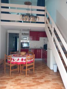 a kitchen with a dining room table and a staircase at La Petite de Cayola in Talmont