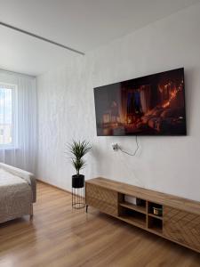 a living room with a tv on a white wall at Cozy Butukas in Kėdainiai