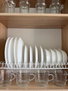 a shelf with plates and cups on it at Cozy Butukas in Kėdainiai