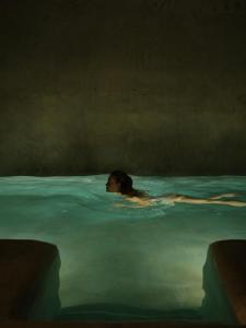eine Frau, die in einem Wasserbecken schwimmt in der Unterkunft Doda Artisanal Cave Hotel 14 Plus in Ortahisar