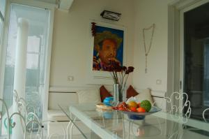 a dining room with a glass table with a bowl of fruit at Sonomusica B&B in Gazzola Di Rivalta