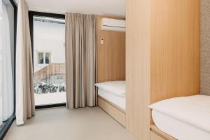 a small room with two beds and a window at B Kaprun in Kaprun