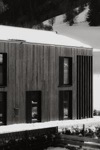 a building with windows and snow on the ground at B Kaprun in Kaprun +8 photos