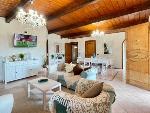 a living room with a couch and a table at VILLA PRAXEDES con piscina a Nettuno in Nettuno