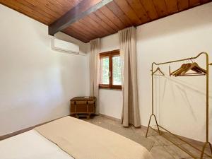 a bedroom with a bed and a window at VILLA PRAXEDES con piscina a Nettuno in Nettuno