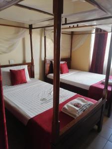 two bunk beds in a room with red pillows at The Folks Inn in Mombasa +14 photos