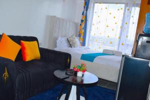 a living room with a couch and a table at Elegant studio apartment in Kiambu Road Tsavo Apartments in Kiambu