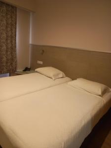 a bedroom with two beds with white sheets and a window at Guesthouse Bocage in Setúbal