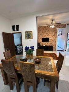 a dining room with a wooden table and chairs at waterspring home in Banyuwangi