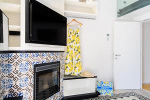 a living room with a fireplace with a flat screen tv at Amalfi Gallery Room & Suite in Amalfi