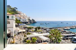 a view of a city with a harbor and the ocean at Amalfi Gallery Room & Suite in Amalfi