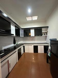 a kitchen with black and white cabinets and a counter at waterspring home in Banyuwangi +18 photos