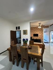 a dining room with a wooden table and chairs at waterspring home in Banyuwangi