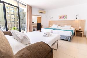 a hotel room with two beds and a couch at Hotel Mainare Playa in Fuengirola +60 photos