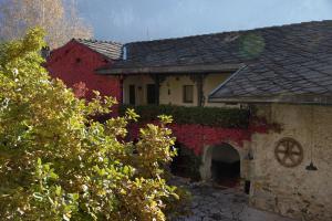une maison avec du lierre rouge sur son côté dans l'établissement B&B Castel Ivano, à Strigno