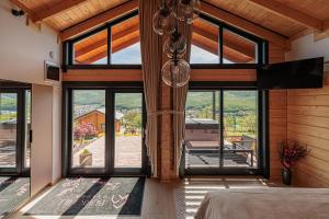 a bedroom with large windows and a bed in a room at Bükk Hill Garden in Miskolc