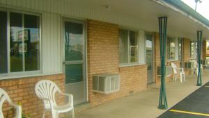 a brick building with white chairs and windows at Alma Motel in Alma