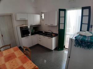a kitchen with white cabinets and a table and a table and a tableablish at Via Piave 14 in Santa Cesarea Terme