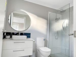 a bathroom with a white toilet and a mirror at Family-friendly Seaside Gem in Urangan +53 photos