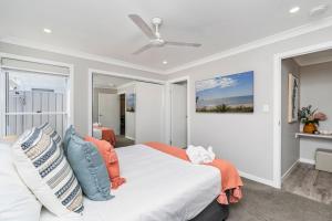 a bedroom with a bed and a ceiling fan at Family-friendly Seaside Gem in Urangan