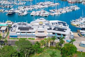 a large white building with boats in a marina at Family-friendly Seaside Gem in Urangan
