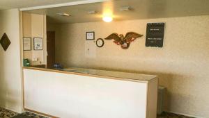 a counter with a cell phone and a clock on the wall at Alma Motel in Alma