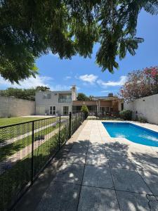 a house with a swimming pool and a fence at Hospedaje Buena Vibra in San Nicolás de los Arroyos