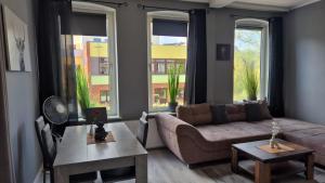 a living room with a couch and two large windows at Stadtnah an der Förde 65 1 in Flensburg