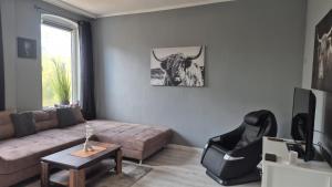 a living room with a couch and a bull on the wall at Stadtnah an der Förde 65 1 in Flensburg