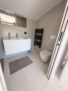 a bathroom with a white sink and a toilet at Les hauts de Vaison in Vaison-la-Romaine