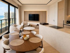a living room with a table and chairs at Herbert Samuel Okeanos Suites Herzilya in Herzliya