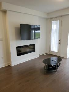 a living room with a table and a fireplace at Lake breeze water view in Bowmanville