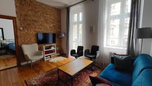a living room with a blue couch and a brick wall at Prad 543 in Poznań