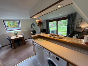 a kitchen and living room with a washer and dryer at Loch Oich Lodge in Invergarry