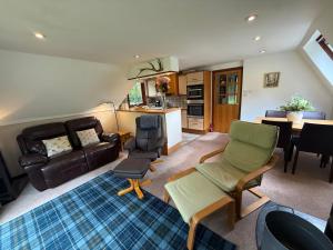 a living room with a couch and a table at Loch Oich Lodge in Invergarry