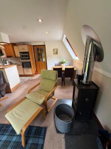 a living room with a kitchen and a table at Loch Oich Lodge in Invergarry +1 photo